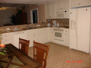 Fully stocked kitchen with stone tile floors and granite countertops. 