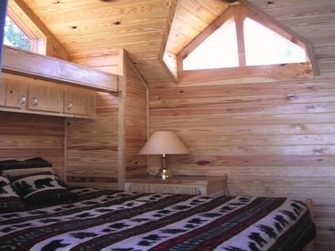 Master bedroom with king sized bed, chalet dormers, ceiling fan, flat screen TV and DVD player.  Sliding glass doors open to small deck.