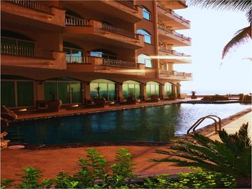 Pool from lobby exit; opens to ocean and stairs to beach