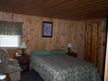 Main bedroom with queen sized bed, taken before remodeling. New floor and new headboard/footboard. 