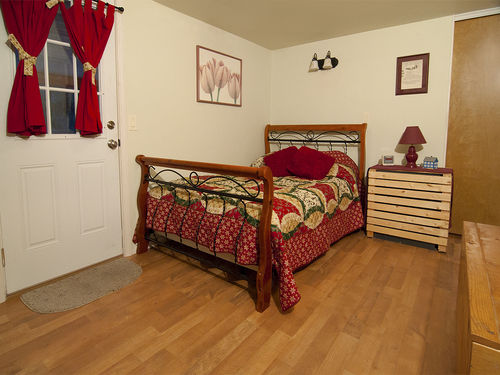 Spacious bedroom with hardwood floors, a private bath and door to the covered hot tub.