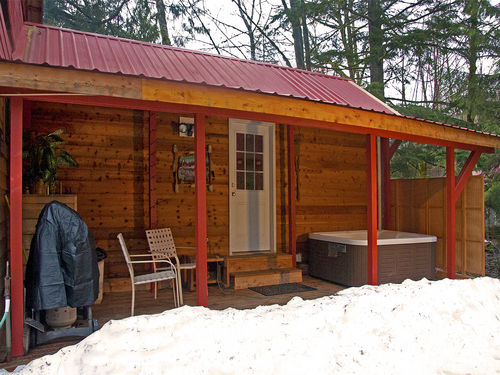 The hot tub is covered, and a charcoal grill is available.