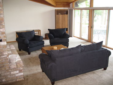 Open concept living room with vaulted wood beam ceiling and fantastic views of the lake both day and night.