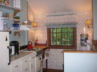 Kitchen with refrigerator, stove/oven, coffeemaker and microwave.