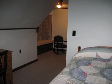 This bedroom in the Salmon House has a window seat in the bay window and windows looking towards Johnsons Bay.