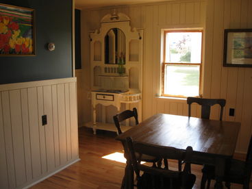 The dining room has wood paneling and a new hardwood floor