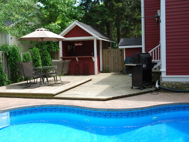 Private, fenced yard with heated pool, outdoor bar, dining area, Gas BBQ, Double Hammock and a play area for children