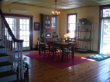Open concept main floor with spacious Dining Room with Harvest table, French doors and original pine floors. 