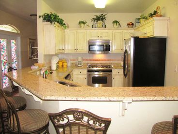 Big kitchen with breakfast bar open to dining and living rooms.