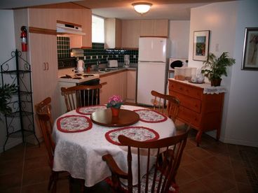 Open concept fully-equipped kitchen with fridge, oven, microwave, kettle, coffee maker, toaster, expandable dining room table, double-sink, utensils, pots & pans, plates, hot-air popcorn maker, and much more.