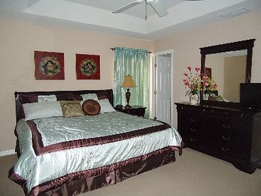 master bedroom with king bed and inside bathroom