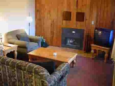 Large room with comfortable seating including a queen sleeper sofa for additional guests. Gas log fireplace and large TV with basic cable.
