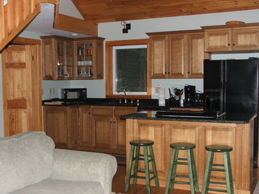 The kitchen, living room and dining room are one large room with knotty pine tongue in groove cathedral ceilings. The kitchen is fully equipped.