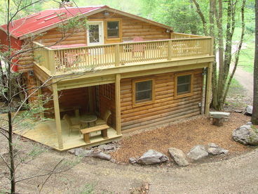 Rear of cabin, with open 16x26 ft deck and one of three covered porches