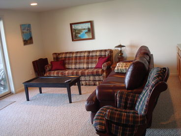 Lower Level Walk out is spacious, has a lot of seating (can\'t see in photo), fireplace, TV, sofa sleeper, futon, laundry room and a full bath. Patio area.