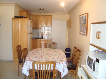 kitchen includes refridgerator, stove top, microwave, hot tray, dishes