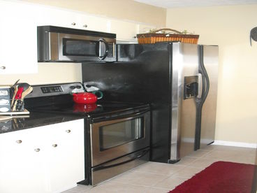 Kitchen with granite counter tops, tile floors, and stainless steel appliances 