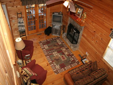 Over looking the main level from the loft brings you a cozy fireplace and screened in outside dining!