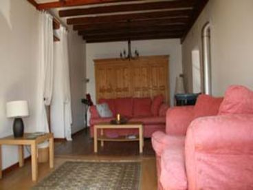 Large sitting room with wood burning stove and double doors out to covered terrace.