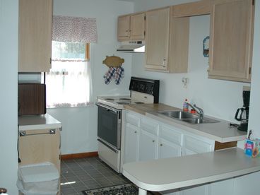 Kitchen has a stove, microwave and basic kitchen items.