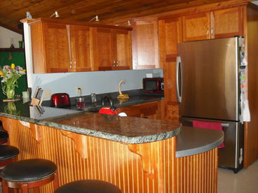 Fully stocked kitchen ready for entertaining! Opens onto great room, screened porch and private yard.