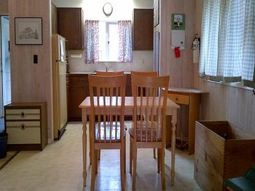 The dining area has a solid wood table and chairs.