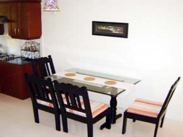 The dining room is adjacent to the kitchen and features a 6 seater glass dining table and 6 chairs