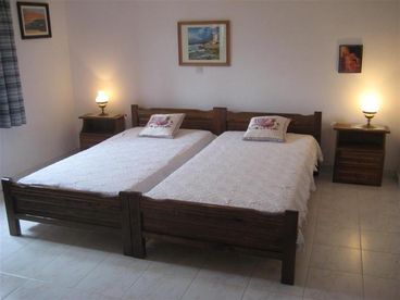 The master bedroom with two twin size beds and side tables.