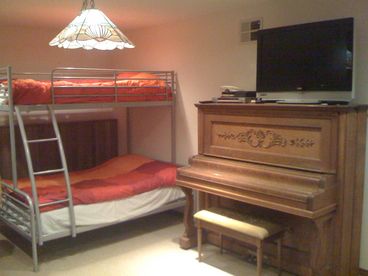 Game Room, daylight basement level.  Full bed on bottom bunk, with single on top.  Loveseat, Foosball table and Air Hockey.
TV is 37\