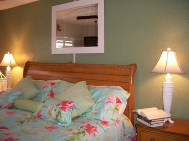 Master bedroom with king size bed and a large window with views of the ocean.