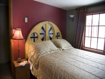 Headboard donated by a South Minneapolis church. This room boasts a queen-sized bed and views of both the garden and the back yard. 