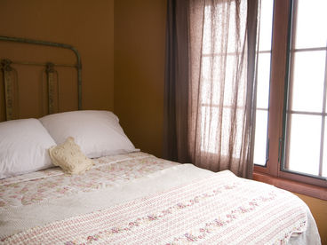 This bedroom is adjacent to the sitting room and has a view of the beautifully lush courtyard.