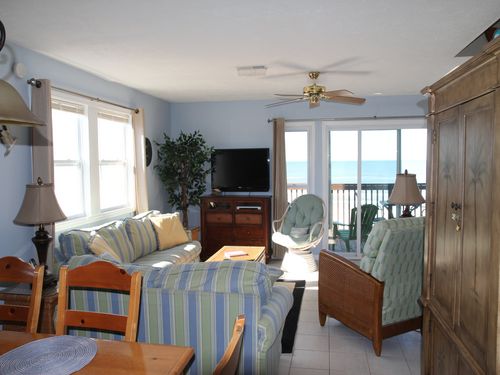 Looking from kitchen through dining area to living room.  Main level deck outside the sliding glass doors