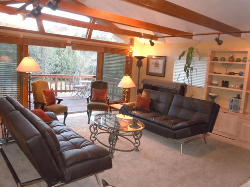 Living room features vaulted ceilings, HGTV and a large private deck