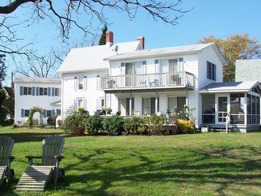 View of the rear of the house showing screened in porch and decks, hot tub area and garage beyond