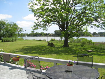 View of the back deck. yard, and dock from the family room and kitchen area