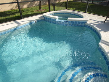 Pool attached to the vacation home, with spa and screen enclosure.