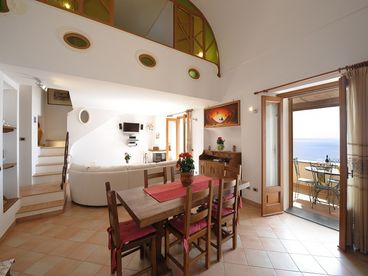 sitting and dining area with the tv satellite two french door-balcony with sea view