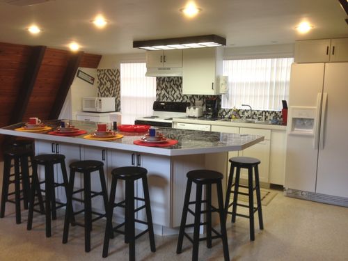 The sun-drenched eat-in full kitchen with the huge granite breakfast bar island that seats 8!