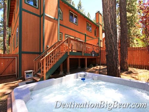 The fenced in flat back yard with an inviting hot tub