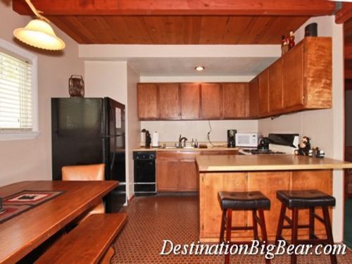 The kitchen has a large dining table, a bar for extra seating, a dishwasher, and all the needed amenities for preparing meals