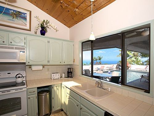 Huge kitchen with two islands faces pool and has door to back yard