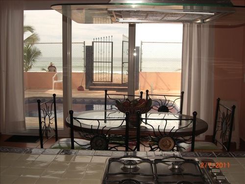 The diningroom table looks out at the pool and beach beyond.