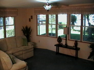 Living room area with sectional reclining sofa looking overlooking lake