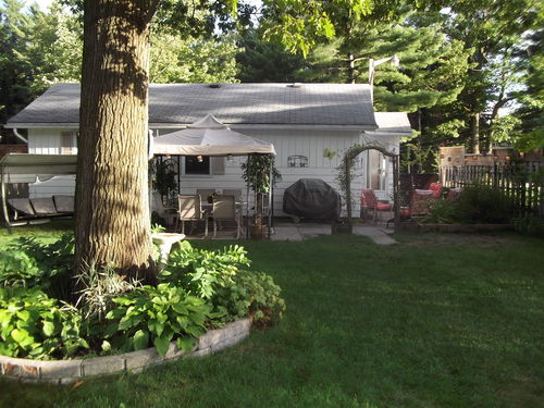 Large fenced yard with patio dining area, horseshoe pit and fire pit.
