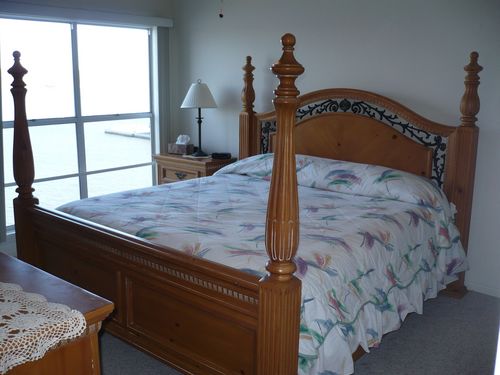 King bed in the master bedroom and a great view of the lake. One can hear the water lapping at the shore. 