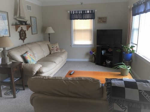 Great room with comfortable couches and TV with picture window to view outside the Virginia Beach area.