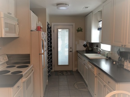 Great equipped eat in kitchen with dishes and pots and pans, dishwasher, stove eat in area.