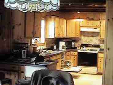 Modern kitchen with dishwasher, disposer, electric range and all dishes and cookwear.