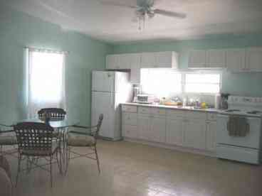 The kitchen in the upstairs apartment is spacious and sunny, and has sliding doors out to a huge terrace with beautiful ocean views.